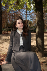 a lady in a white shirt, a grey jacket and a grey skirt